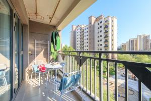 a balcony with a table and chairs on a building at Locals Apartment Inn 14 in Tianjin