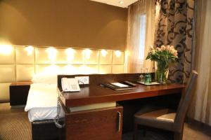 a hotel room with a bed and a desk with a telephone at Prielmayerhof HOTEL in Linz