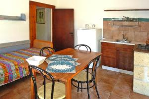 a dining room with a table and chairs and a kitchen at Apartment in the Centra Vacanze il Borgo resort in Guardistallo in Guardistallo