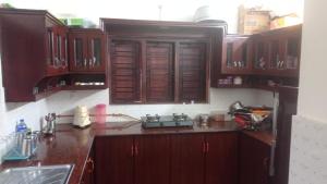 a kitchen with wooden cabinets and a stove in it at CANALVIEW PRIVATE COTTAGE Azhikkal Ayiram Thengu in Perinād