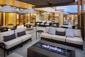 a patio with couches and tables and a fireplace at Hyatt Place Scottsdale North in Scottsdale