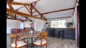 una cucina e una sala da pranzo con tavolo e sedie di Domaine les jardins de la Saône a Tournus