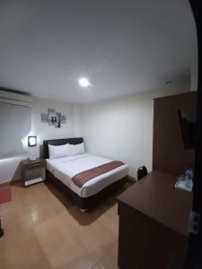 een slaapkamer met een groot bed in een kamer bij Grand Avira Hotel in Batu Merah