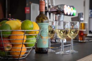two glasses of white wine next to a basket of fruit at The Caledonian New Southlands Hotel in Scarborough