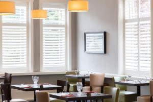 a dining room with tables and chairs and windows at The Caledonian New Southlands Hotel in Scarborough +24 photos