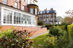 a garden in front of a large brick building at The New Southlands Hotel in Scarborough