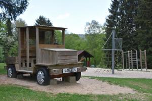 een houten truck geparkeerd voor een speeltuin bij Ferienhaus Nr 18A3, Feriendorf Hagbügerl, Bayr Wald in Waldmünchen
