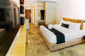 a bedroom with a large bed in a room at Graha Socio Hotel Nusa Dua Bali in Nusa Dua