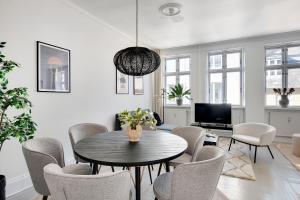 - un salon avec une table, des chaises et une télévision dans l'établissement Sanders City - Nimble One-Bedroom Apartment In the Lovely Capital, à Copenhague