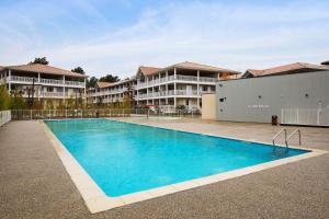 una piscina frente a unos edificios de apartamentos en Appartement des Asphodèles - Welkeys, en La Teste-de-Buch