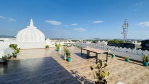 a rooftop patio with a table and a building at Kotra Haveli A Boutique Hotel by Lake Pichola in Udaipur