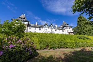ein Schloss auf einem Hügel mit Blumen in der Unterkunft The Highland Hotel by Compass Hospitality in Strathpeffer