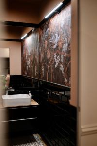 a bathroom with a sink and a painting on the wall at Apartamenty Zamkowe Centrum in Kwidzyn +35 photos