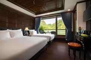 Habitación de hotel con 2 camas y ventana en La Casta Regal Cruise en Ha Long