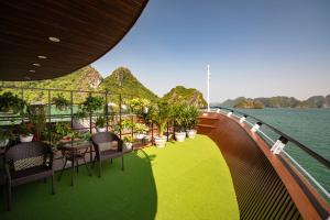 a balcony with tables and chairs on a cruise ship at La Casta Regal Cruise in Ha Long