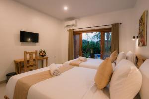 1 Schlafzimmer mit 2 Betten, einem TV und einem Fenster in der Unterkunft Mag Canggu Bali By Hospitality Bali in Canggu