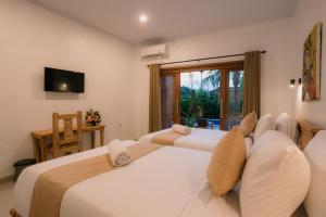 a bedroom with two beds and a tv and a window at Mag Canggu Bali By Hospitality Bali in Canggu