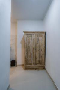 ein Holzschrank in der Ecke eines Zimmers in der Unterkunft Mag Canggu Bali By Hospitality Bali in Canggu