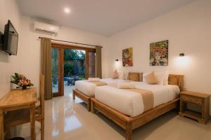 1 Schlafzimmer mit 2 Betten und einem TV in der Unterkunft Mag Canggu Bali By Hospitality Bali in Canggu
