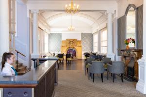 una mujer sentada en un bar en un restaurante en The Royal Hotel Weymouth, en Weymouth