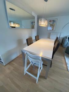 uma mesa branca e cadeiras numa sala de estar em Ferienwohnung I Ferienhaus am Bodensee I Meersburg I Sauna I Fitness em Meersburg