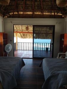 1 dormitorio con 2 camas y vistas al océano en Cabañas Alta Mar en Guayabas