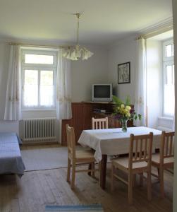 ein Esszimmer mit einem Tisch, Stühlen und einem TV in der Unterkunft Villa Pranter in Sillian