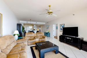 a living room with couches and a flat screen tv at Navarre Beach Regency 308 in Navarre