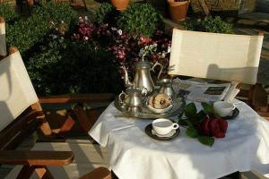 a table with a tea kettle and a bowl of food at Hotel Petrino in Makrinítsa
