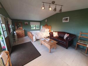 a living room with a bed and a couch at Marshland Alpacas Glamping Lodge in New Holland