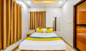 Un dormitorio con una cama con almohadas amarillas y coloridas en Itsy By Treebo - Shri Guru Service Apartment, en Nagpur