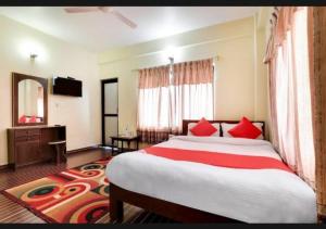 a bedroom with a large bed with red pillows at Hotel The Lake in Pokhara