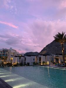 una grande piscina con palme e edifici di luxury sea view Address Hotel apartment Fujairah a Fujaira