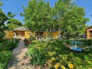a yard with a yellow house with a picnic table at Zangazur hotel & cottages in Qusar