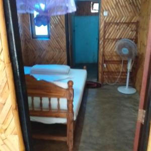 Cette chambre comprend un lit et un ventilateur. dans l'établissement Scoop Cabana Kitesurfing, à Kalpitiya