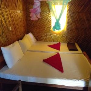 a bed in a bamboo room with a window at Scoop Cabana Kitesurfing in Kalpitiya