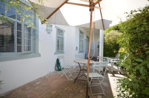een paraplu op de patio van een huis bij Willow Cottage in Kaapstad