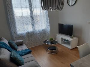 a living room with a couch and a tv at Duplex tout confort - circuit 24h - pôle santé sud - Centre des expositions - Technoparc in Le Mans