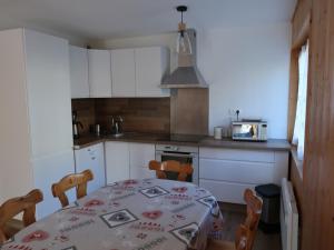 a kitchen with a table and chairs and a kitchen with white cabinets at Appartement Valloire, 3 pièces, 8 personnes - FR-1-263-455 in Valloire