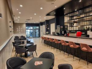 un restaurante con mesas y sillas y un bar en D50 Hotel, en Budapest