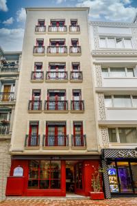 a tall building with red doors and balconies at La Porte de Taksim in Istanbul