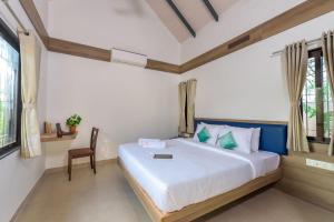 a bedroom with a bed and a chair in it at SaffronStays Eden, Nashik - pet-friendly villa with pool, jacuzzi & grape farm in Nashik +22 photos