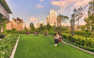 新加坡lyf Farrer Park Singapore的坐在公园草地上长凳上的女人