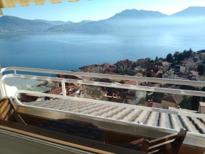 a balcony with a view of a city and water at Viewpoint Cannero Apartment in Cannero Riviera