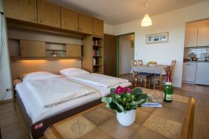 Un dormitorio con 2 camas y una mesa con una botella de vino. en Appartment 1614, Ferienpark Oberallgäu, Schwimmbad, Sauna, Spielplatz, en Missen-Wilhams