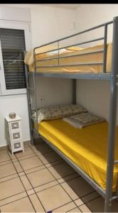 a bunk bed in a room with a yellow bedsheet at Villa Irene in Gandía