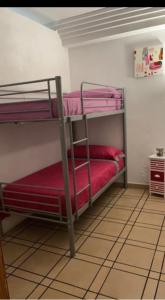 a room with two bunk beds with red sheets at Villa Irene in Gandía