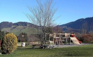 Ferienwohnung Nr 18, Golf- und Ski-Residenz, Oberstaufen-Steibis, Allgäu في اوبرستوفن: ملعب في حقل مع شجرة