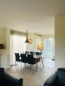 a dining room and living room with a table and chairs at Strand Villa Stern Noordwijk in Noordwijk