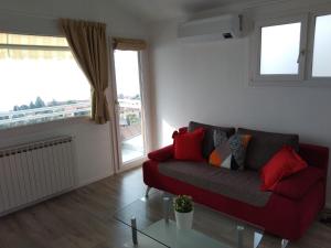 a living room with a red couch and a glass table at Viewpoint Cannero Apartment in Cannero Riviera